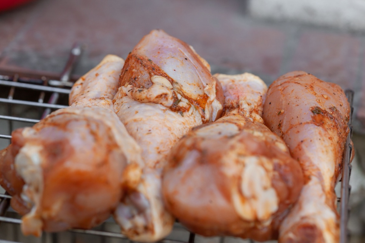 Seasoned chicken drumsticks laid out on a rack